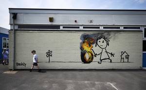 Παιδικά... παιχνίδια μπροστά από την τοιχογραφία του Banksy.