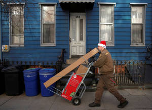 Ταχυδρόμος στο Μπρούκλιν είναι στο κλίμα των εορτών και την ώρα που εργάζεται. Παραδίδει τα πακέτα του, φορώντας ένα σκουφί Άγιου Βασίλη.