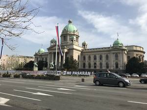 Πανό και συνθήματα έξω από το Κοινοβούλιο της Σερβίας με αφορμή τα 19χρονα από τους ΝΑΤΟϊκούς βομβαρδισμούς
