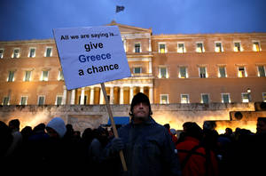 Με ένα παραποιημένο στίχο από το Give Peace a Chance του Τζον Λένον, ένας διαδηλωτής ζητά μία ευκαιρία για την  Ελλάδα, κατά τη διάρκεια διαδήλωσης στήριξης της νέας κυβέρνησης, τον Φεβρουάριο του 2015, που βρίσκεται εν μέσω σκληρών διαπραγματεύσεων με το