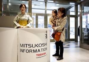 Οι επισκέπτες παρατηρούν το κιμονό που φοράει το ρομπότ Άικο Τσιχίρα, που δημιουργήθηκε από την εταιρεία Toshiba. Το ανθρωπόμορφο ρομπότ βρίσκεται σε ένα εμπορικό κέντρο του Τόκιο. Μπορεί να μιλήσει και να συστηθεί στους πελάτες.