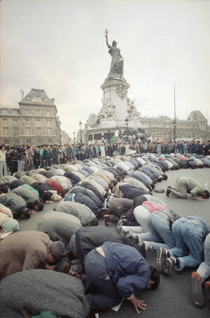Μουσουλμάνοι προσεύχονται προς τη Μέκκα, το 1989, στην Place de la Republique στο Παρίσι. Έχουν προηγουμένως διαδηλώσει εναντίον του Ρούσντι και του βιβλίου του.