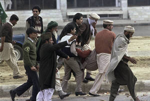 Ένας διαδηλωτής τραυματίζεται από αστυνομικούς, κατά τη διάρκεια βίαιων διαμαρτυριών εναντίον του Ρούσντι και του βιβλίου του στο Ισλαμαμπάντ του Πακιστάν, το 1989.