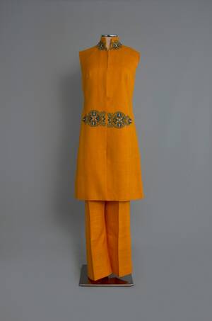 Σύνολο από πορτοκαλί λινό ύφασμα της Cleo’s Art Souvenirs με κεντημένη «πόρπη»
Αθήνα. Δεκαετία 1960
Δωρεά: Κλειώ Μποσταντζόγλου