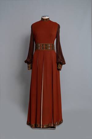 Φόρεμα μάξι από καφέ κρεπ με ενυφασμένα γεωμετρικά σχέδια του οίκου “Nikos-Takis”
Δεκαετία 1970
Δωρεά: Νένα Σακελλαροπούλου