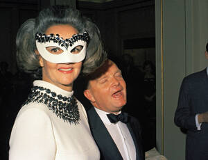 1966, Ουάσινγκτον. Η εκδότης της Washington Post, Κάθριν Γκράχαμ, φορώντας μια μάσκα, σε ένα από τα περίφημα Black and White πάρτι του Τρούμαν Καπότε, ο οποίος είναι δίπλα της.
