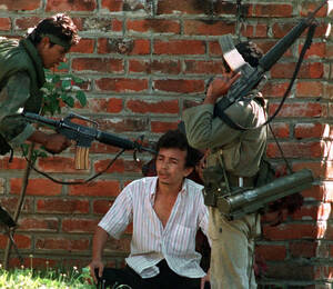 1989, Σαν Σαλβαδόρ. Ένας κυβερνητικός στρατιώτης του Ελ Σαλβαδόρ σημαδεύει στο κεφάλι έναν ύποπτο για αντικυβερνητική δράση, σε ένα προάστειο του Σαν Σαλβαδόρ.