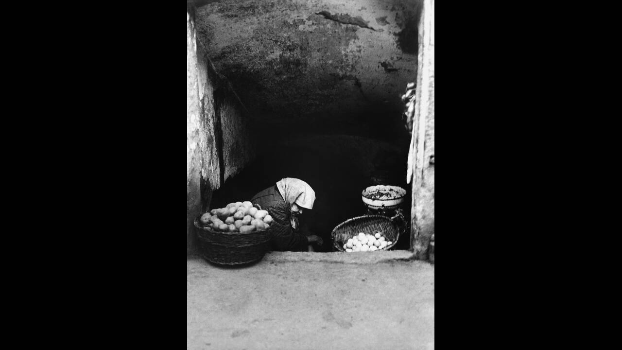 1931, Οικονομική κρίση στη Ρουμανία:
Μια φτωχή Ρουμάνα με τα λιγοστά αποθέματα τροφίμων της σε ένα κελάρι στο Βουκουρέστι.