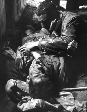 1968, Βιετνάμ, η μάχη του Hue:
Ένας τραυματισμένος πεζοναύτης φωνάζει και προσεύχεται ενώ ένας επίσης τραυματισμένος συνάδελφός του προσπαθεί να τον ηρεμήσει, στο παράπηγμά τους.