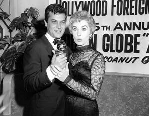 1958
Ο ηθοποιός Τόνι Κέρτις κρατάει τη Χρυσή Σφαίρα που κέρδισε, έχοντας δίπλα του στη σύζυγό του, Τζάνετ Λι.