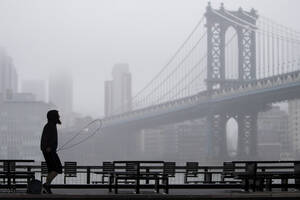Ένας άντρας βαδίζει μόνος τους στη γέφυρα του Μανχάταν.