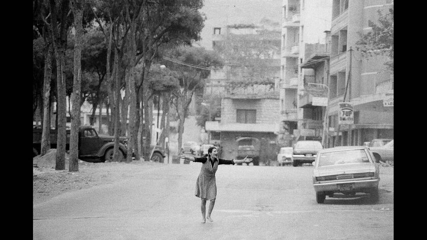 1975, Βυρητός. Μια γυναίκα φωνάζει σε οπλισμένους άντρες σε ένα δρόμο της Βυρητού. Ο άντρας της σκοτώθηκε λίγο νωρίτερα σε μια ανταλλαγή πυρών ανάμεσα σε Παλαιστίνιους αντάρτες και δυνάμεις του λιβανέζικου στρατού.